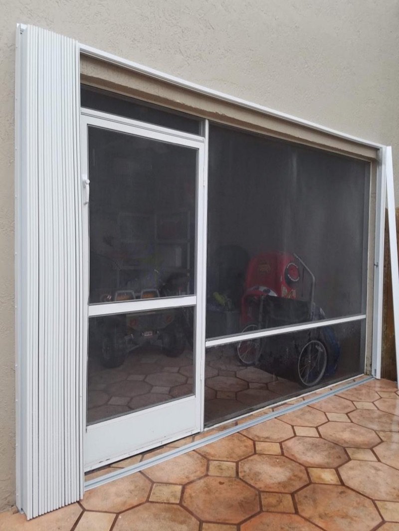 Accordion shutter beside a patio screen enclosure