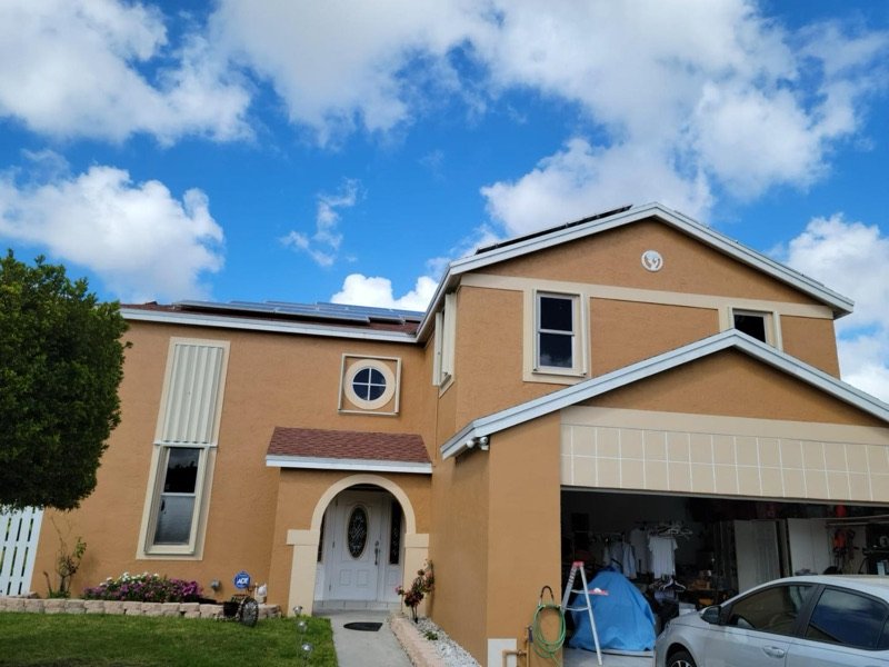 Miami two-story home with hurricane shutters under a blue sky