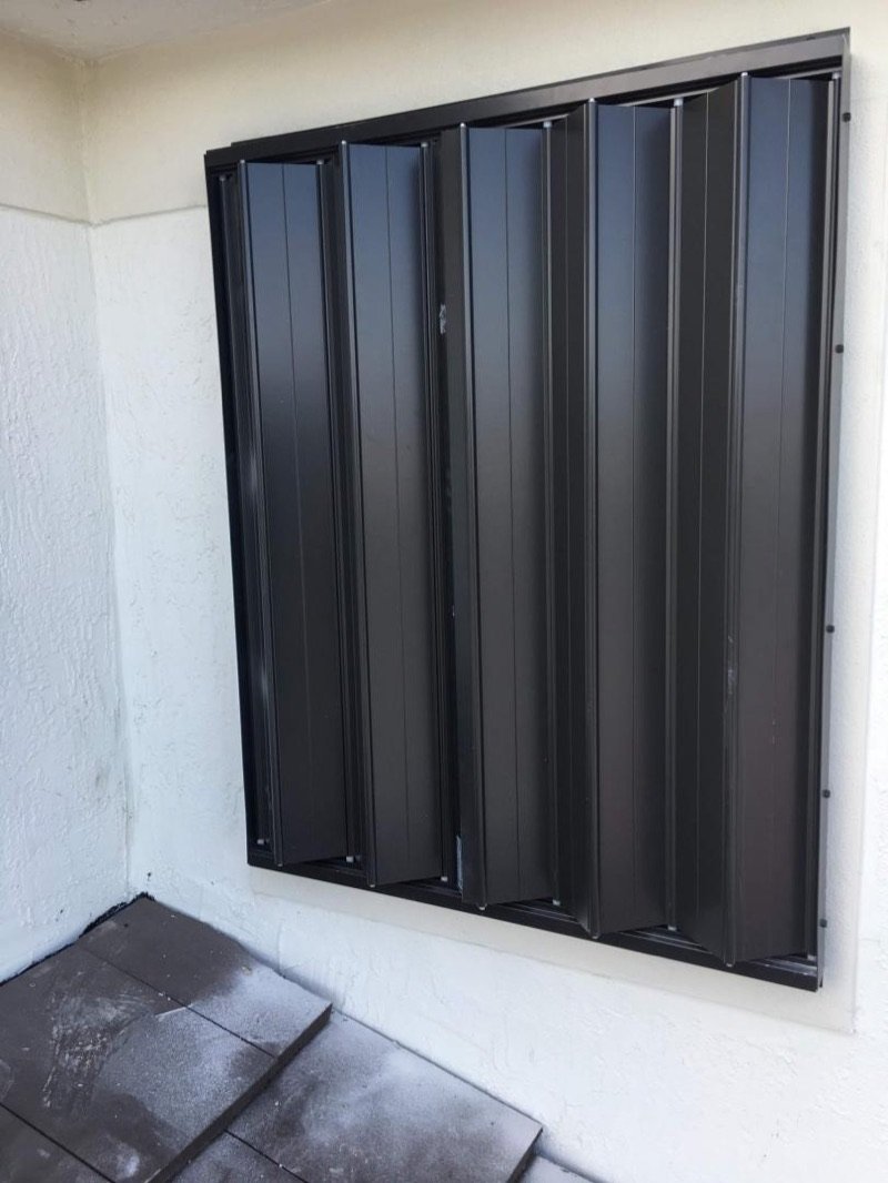 Black storm panel installed over a window in Miami-Dade